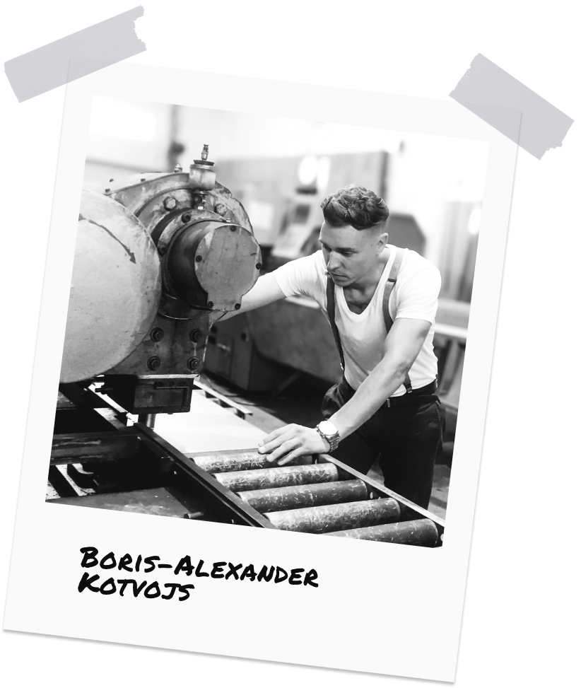 Boris-Alexander Kotvojs, Gründer und Geschäftsführer der stonearts® GmbH, arbeitet an einer Maschine. Er trägt ein weißes T-Shirt und konzentriert sich auf die Bedienung der Maschine.