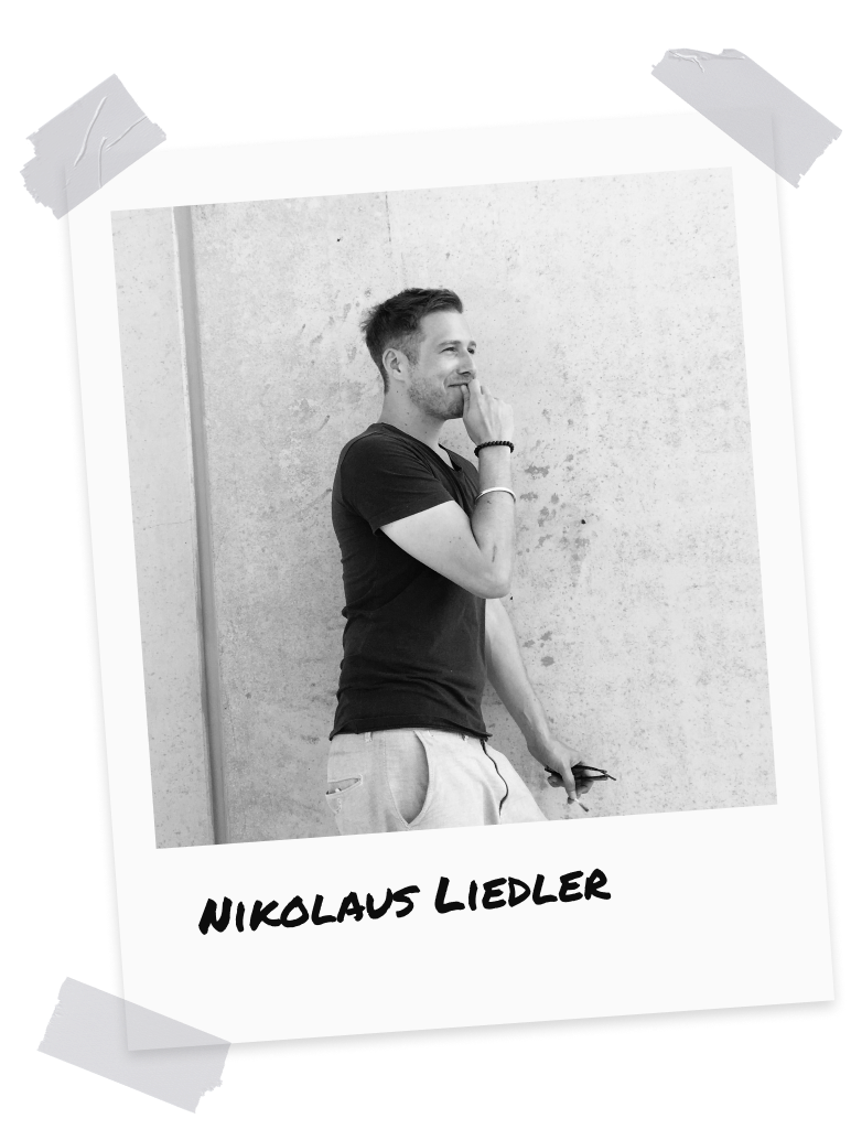 Nikolaus Liedler, Managing Director and founder of stonearts® GmbH, stands thoughtfully in front of a concrete wall. He is wearing a black T-shirt and light-colored trousers.