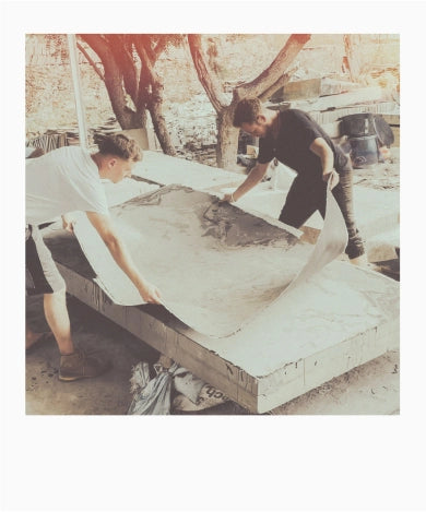 Boris-Alexander Kotvojs and Nikolaus Liedler, two founders of stonearts®, remove a wafer-thin layer of natural stone from a natural stone block at the factory in India.